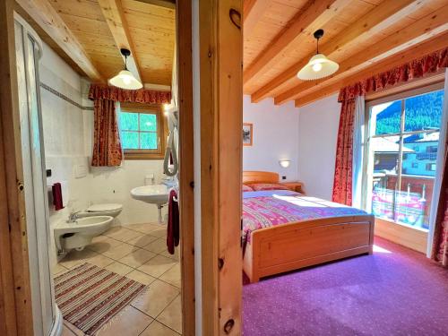 sypialnia z łóżkiem i łazienką w obiekcie Bait da Jembro w Livigno