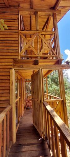 an inside view of a log cabin with a wooden walkway at Cabaña en el Bosque de San José del Pacífico 3 in El Pacífico