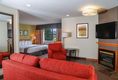 a hotel room with a bed and a couch and a fireplace at Best Western Rocky Mountain Lodge in Whitefish