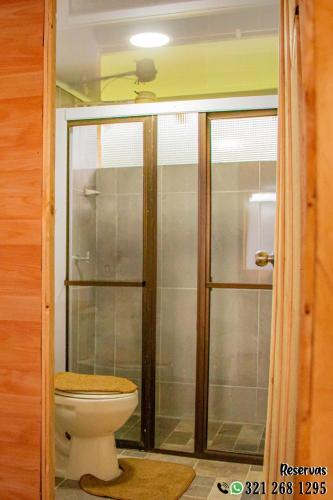 a bathroom with a toilet and a glass shower at Villa Maria in Guatavita