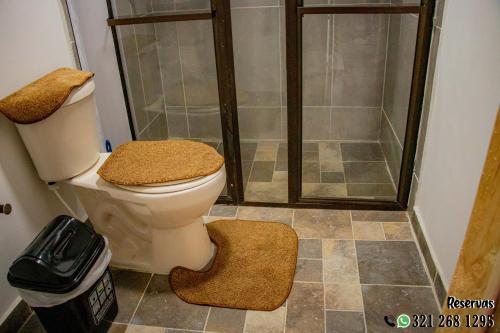 a bathroom with a shower and a toilet with a rug at Villa Maria in Guatavita