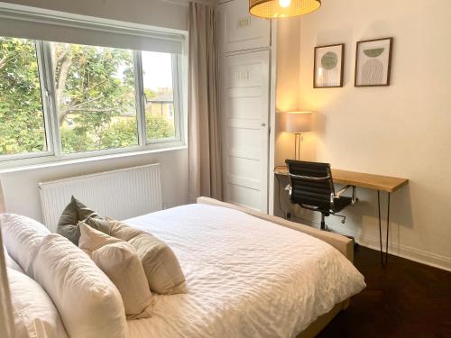 a bedroom with a bed and a desk and a window at Newly refurbished 2 BR Apartment in South London in London