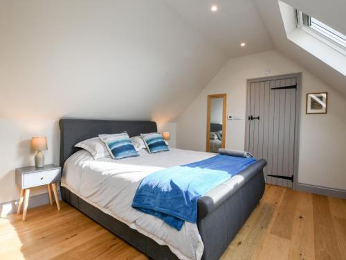 a bedroom with a large bed with blue pillows at The Cart Lodge in Ipswich