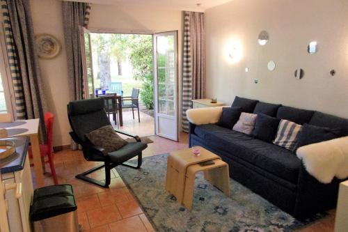 - un salon avec un canapé noir et une chaise dans l'établissement Nice 55m in residence with pool and garden !, à Moliets-et-Maa