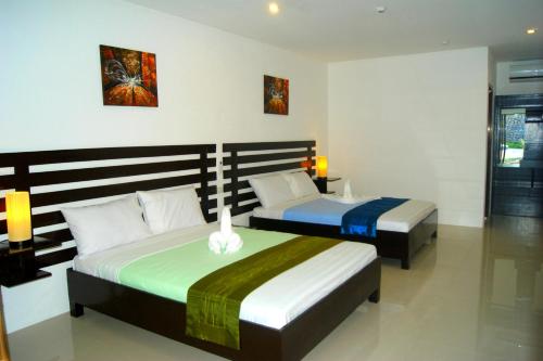 um quarto com duas camas num quarto em Panglao Homes Resort & Villas em Panglao