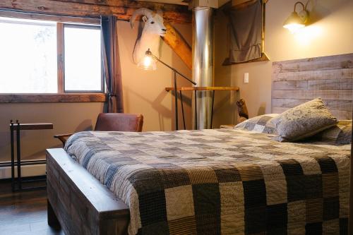 a bedroom with a bed and a deer head on the wall at Arctic Divide Lodge in Dease Lake