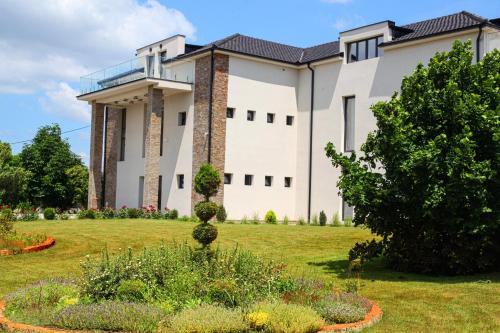 a large building with a garden in front of it at S Club Resort Hotel Aqua Park and Spa in Belgrade