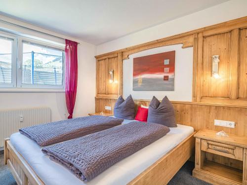 a bedroom with a large bed with red pillows at Gebirgsjagd in Stuhlfelden