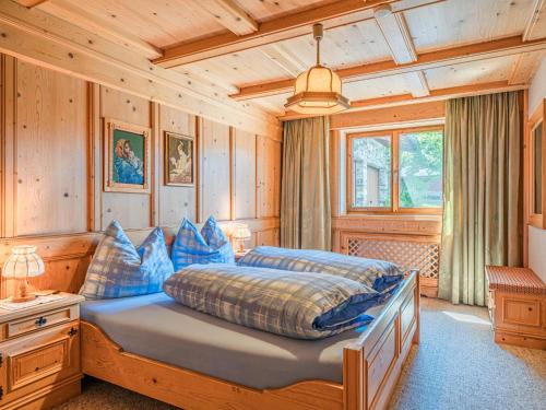 ein Schlafzimmer mit einem Bett in einem Zimmer mit Holzwänden in der Unterkunft Chalet Josef in Westendorf