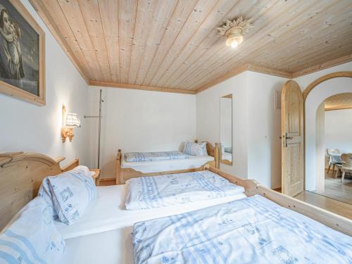 two beds in a room with a wooden ceiling at Weberhof Top 1 in Brixen im Thale