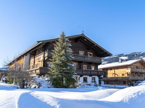 a large wooden building with snow in front of it at Weberhof Top 3 in Brixen im Thale