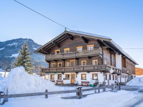 a large wooden house with snow in front of it at Weberhof Top 4 in Brixen im Thale
