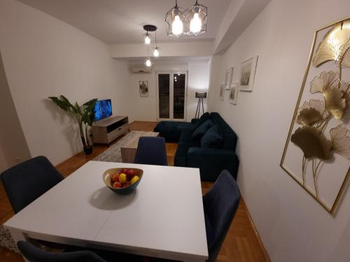 een woonkamer met een witte tafel en blauwe stoelen bij Big apartment in Podgorica