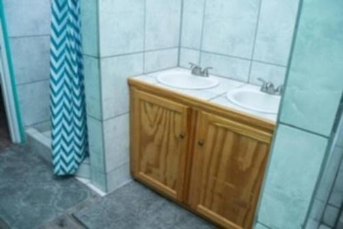 un bagno con due lavandini e una doccia di Glasgow Villa at La Mar a Laborie