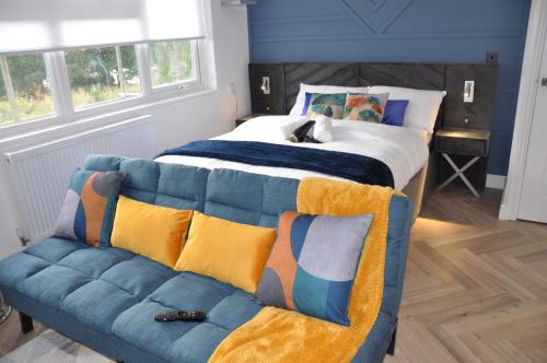 a bedroom with a bed and a couch at Luxury Studio- MK central- 5 MINS DRIVE TO TRAIN STATION-DIRECT TRAINS TO LONDON, BIRMINGHAM in Milton Keynes