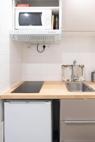 a kitchen with a sink and a microwave at Spacious studio in the center of Montmartre in Paris