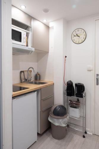 uma pequena cozinha com um lavatório e um micro-ondas em Spacious studio in the center of Montmartre em Paris