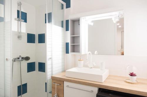 uma casa de banho com um lavatório branco e um espelho. em Spacious studio in the center of Montmartre em Paris