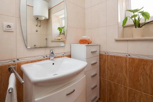 ein Bad mit einem Waschbecken und einem Spiegel in der Unterkunft Seaside house for families with children Sutivan, Brac - 20131 in Sutivan