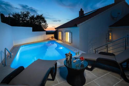 una piscina nel cortile di una casa di Family friendly house with a swimming pool Nerezisca, Brac - 20132 a Nerežišće