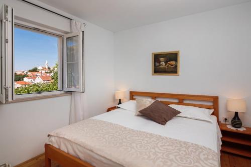 una camera da letto con un letto e una grande finestra di Family friendly house with a swimming pool Nerezisca, Brac - 20132 a Nerežišće