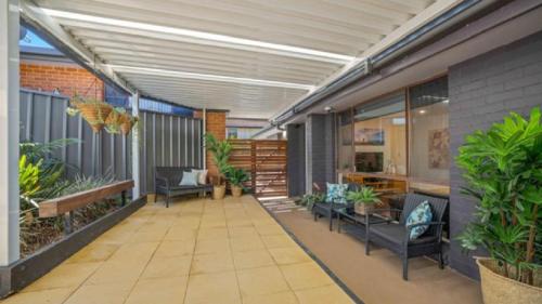 een overdekte patio met stoelen en planten in een gebouw bij Tranquility At Lighthouse Beach in Port Macquarie