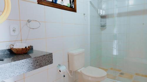 a white bathroom with a toilet and a sink at Pousada Araucária Suítes in Campos do Jordão