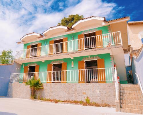 een huis met oranje en groene rand bij Pousada Araucária Suítes in Campos do Jordão