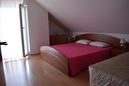 um quarto com uma cama com um cobertor rosa em Kuca za odmor LIBERTA em Pakrac