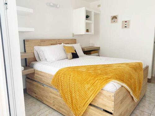 Un dormitorio con una cama de madera con una manta amarilla. en Great apartment D1 en Guatemala