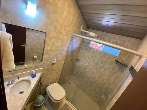 a bathroom with a shower and a toilet and a sink at Chico de Sá Pousada in Pirenópolis