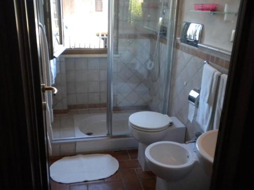 ein Bad mit einer Dusche, einem WC und einem Waschbecken in der Unterkunft appartamento Ciocci in San Gimignano