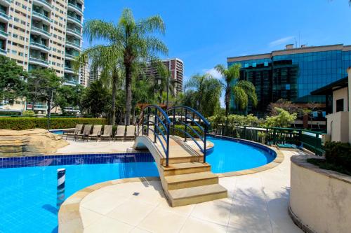 uma piscina com uma escada que leva a um resort em Barra da Tijuca - Flat Premium com cozinha, completinho, moderno e muito confortável no Rio de Janeiro