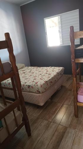 um pequeno quarto com uma cama e uma janela em Chacara em Salto de Pirapora Condomínio Arco Íris em Salto de Pirapora
