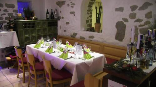 a table in a restaurant with white tables and chairs at Rezas Restaurant Gästehaus in Oberbillig
