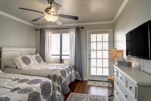 a bedroom with two beds and a flat screen tv at Sand In Your Toes in Mustang Beach