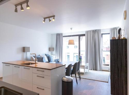 a kitchen and living room with white cabinets and chairs at OneLuxStay near Diamond District in Antwerp