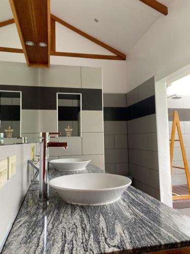 a bathroom with two sinks on a marble counter at Villa MountainView Guesthouse in Dimiao