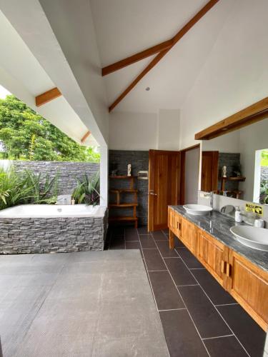 a bathroom with two sinks and a bath tub at Villa MountainView Guesthouse in Dimiao