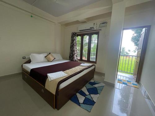 a bedroom with a bed and a large window at Andaman Castle in Port Blair
