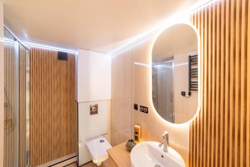 a bathroom with a sink and a mirror at Domy Na Wodzie La Mare Houseboats Bydgoszcz in Bydgoszcz