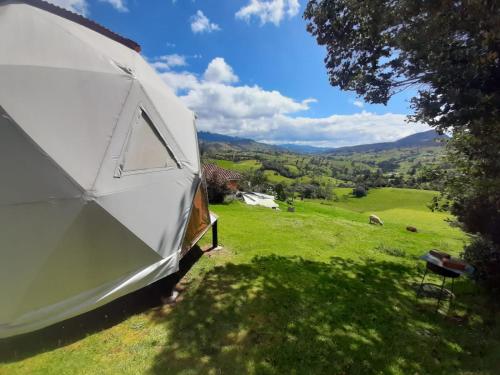 a white tent in a field with a view at Glamping Mi Casita in Guatavita