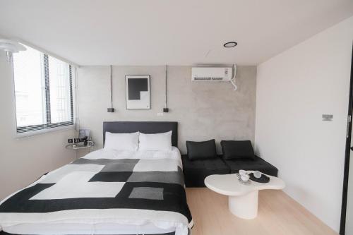 a bedroom with a large bed and a couch at 七七漫旅 Seven77 in Tainan