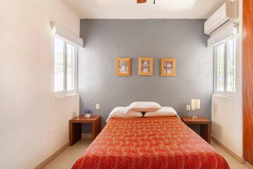 a bedroom with a bed and two windows at Lindo Condominio Acapulco Dorado Amaras ubicación. in Acapulco