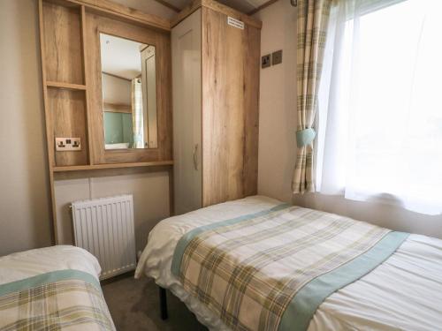 a bedroom with two twin beds and a window at 10 Cheviot View in Berwick-Upon-Tweed