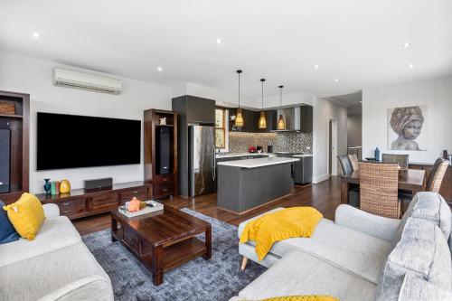a living room with two couches and a kitchen at The SCOOP in Queenscliff