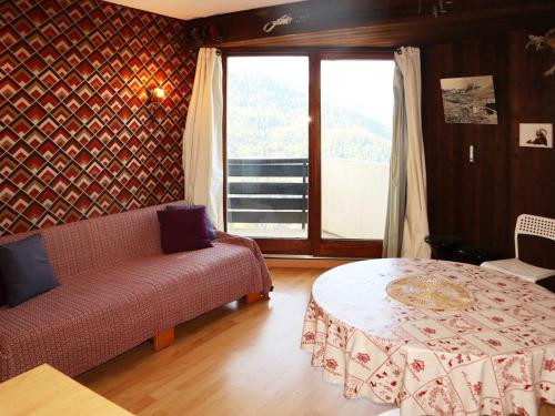 un salon avec un canapé, une table et une fenêtre dans l'établissement Studio skis aux pieds pour 4, balcon - FR-1-322-497, aux Orres