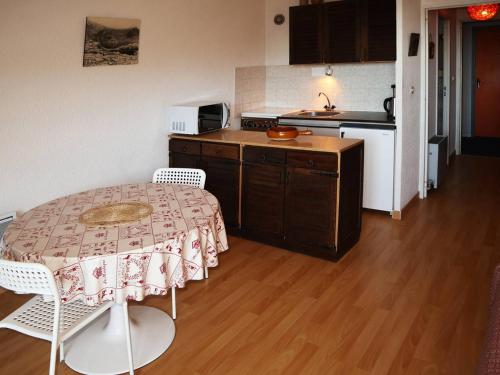 une cuisine avec une table et des chaises dans une pièce dans l'établissement Studio skis aux pieds pour 4, balcon - FR-1-322-497, aux Orres
