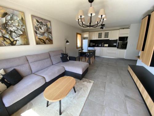 un salon avec un canapé et une table dans l'établissement Charmant appart 2 ch + coin nuit, balcon sud, garage, près de La Clusaz et commerces, St Jean de Sixt - FR-1-459-195, à Saint-Jean-de-Sixt