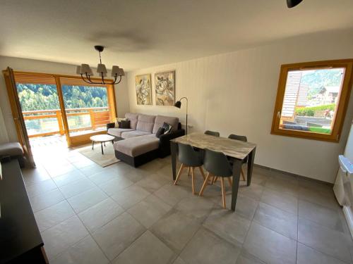 un salon avec un canapé et une table dans l'établissement Charmant appart 2 ch + coin nuit, balcon sud, garage, près de La Clusaz et commerces, St Jean de Sixt - FR-1-459-195, à Saint-Jean-de-Sixt